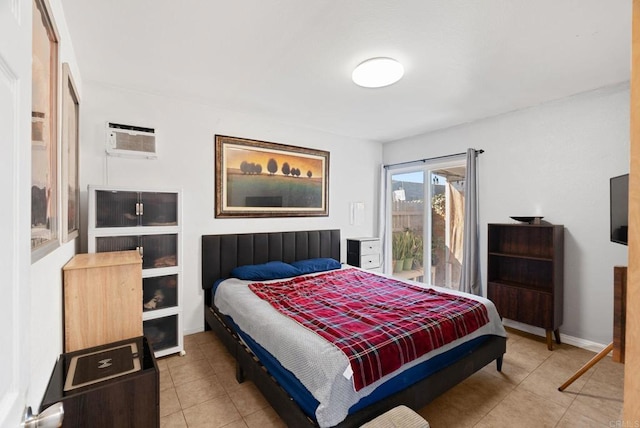 bedroom featuring a wall unit AC, baseboards, and tile patterned floors