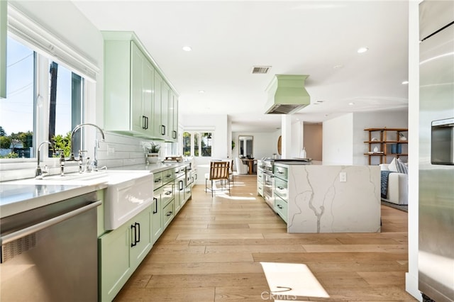 kitchen with stainless steel dishwasher, light wood-type flooring, visible vents, and green cabinetry