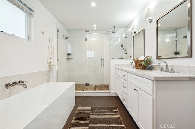 bathroom with double vanity, a soaking tub, a sink, a shower stall, and tile patterned floors