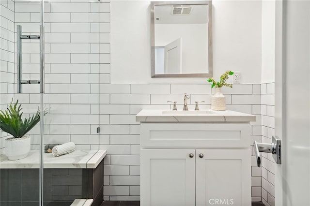 bathroom with vanity and tile walls