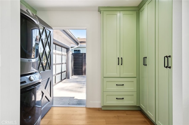 spacious closet featuring light wood finished floors and stacked washing maching and dryer