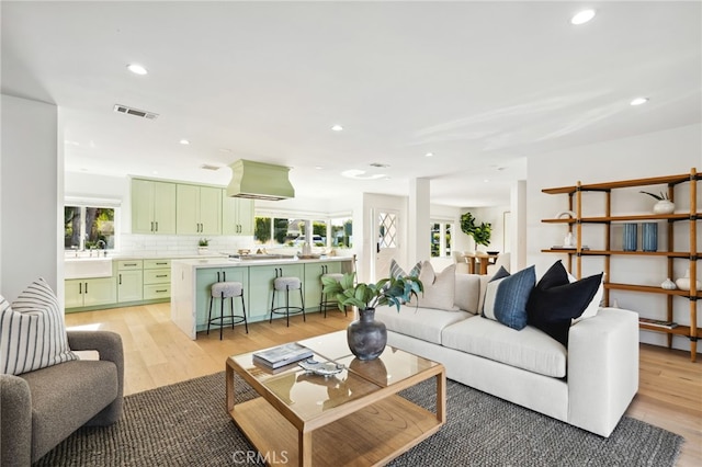 living room with recessed lighting, visible vents, plenty of natural light, and light wood-style flooring