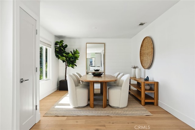 dining area featuring light wood-style flooring, visible vents, and baseboards