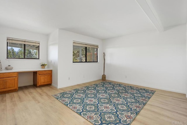 interior space featuring light wood finished floors, built in study area, and a wealth of natural light