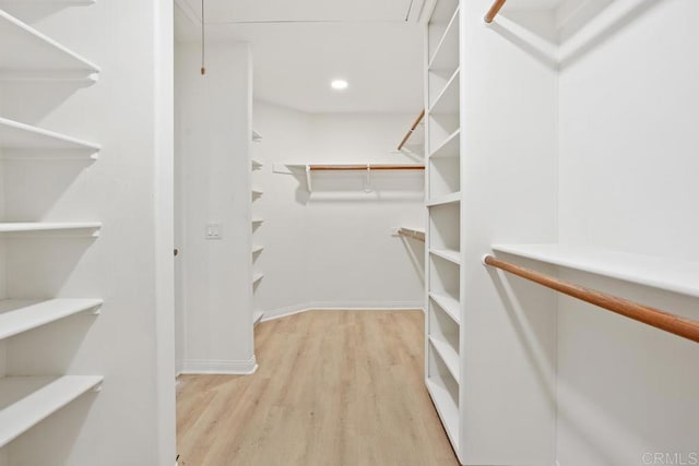 spacious closet with wood finished floors and attic access