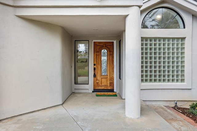 entrance to property featuring stucco siding