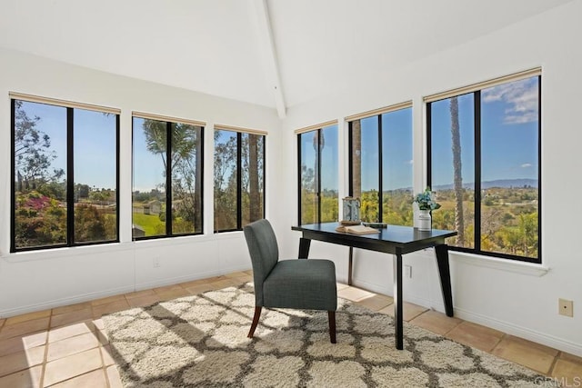 unfurnished office featuring high vaulted ceiling, tile patterned flooring, and baseboards