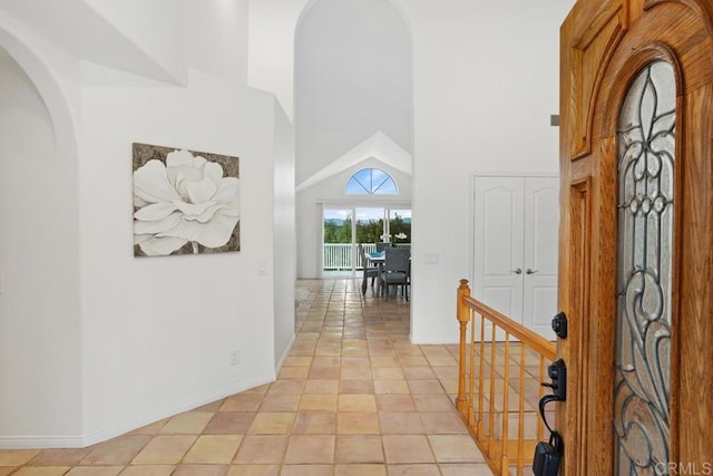 foyer with a high ceiling and baseboards