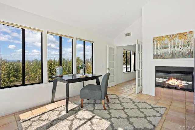 home office with high vaulted ceiling, a multi sided fireplace, and tile patterned floors