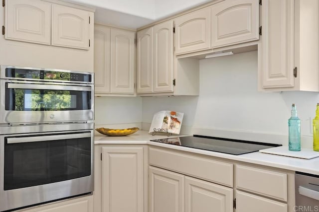 kitchen with light countertops, black electric stovetop, and stainless steel double oven