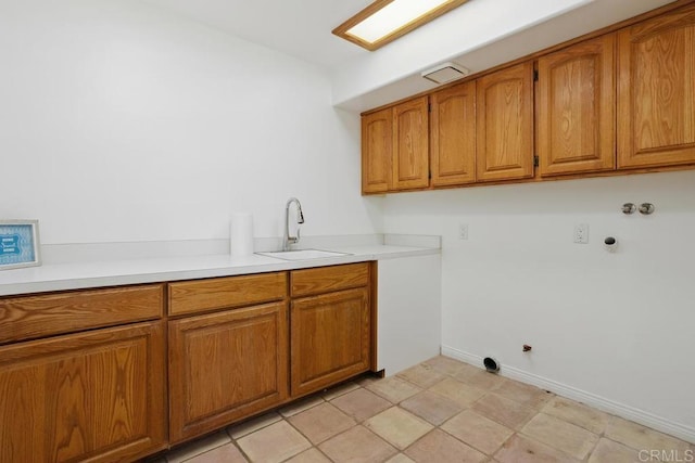 clothes washing area with gas dryer hookup, hookup for a washing machine, a sink, baseboards, and cabinet space