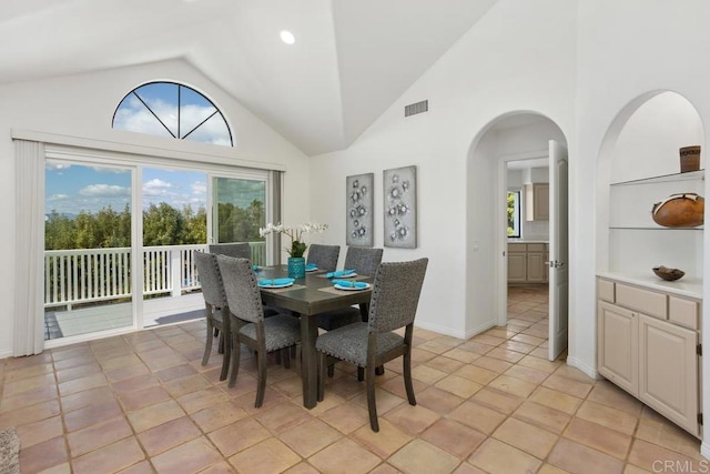 dining space featuring built in features, visible vents, high vaulted ceiling, and baseboards