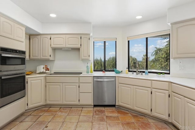 kitchen featuring light countertops, appliances with stainless steel finishes, a sink, and recessed lighting