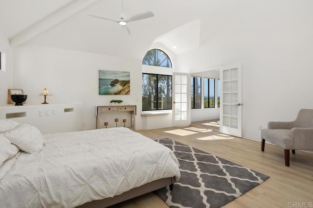 bedroom featuring french doors, beam ceiling, a ceiling fan, wood finished floors, and high vaulted ceiling