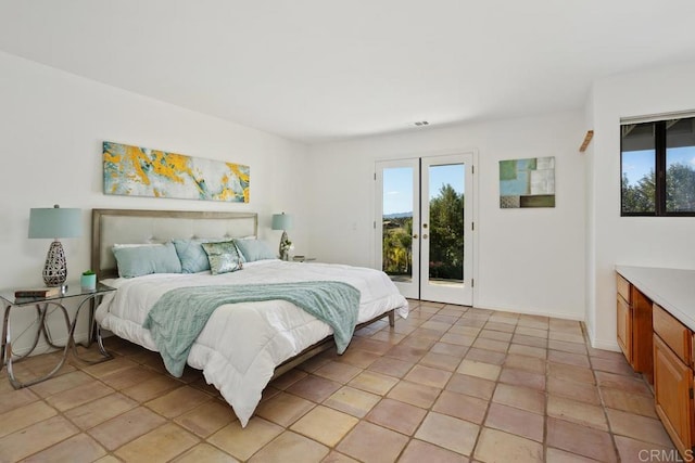 bedroom featuring access to exterior, multiple windows, baseboards, and light tile patterned floors