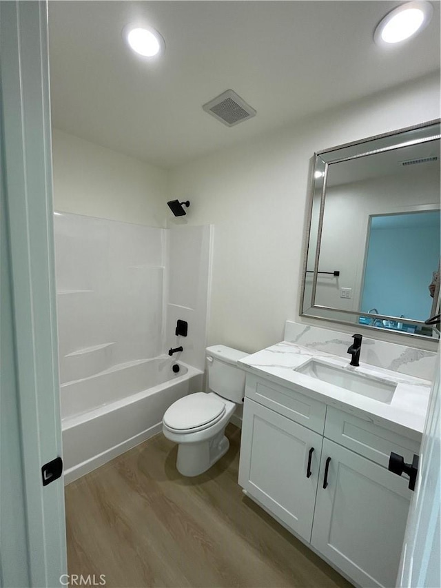 bathroom with visible vents, toilet, wood finished floors, bathtub / shower combination, and vanity