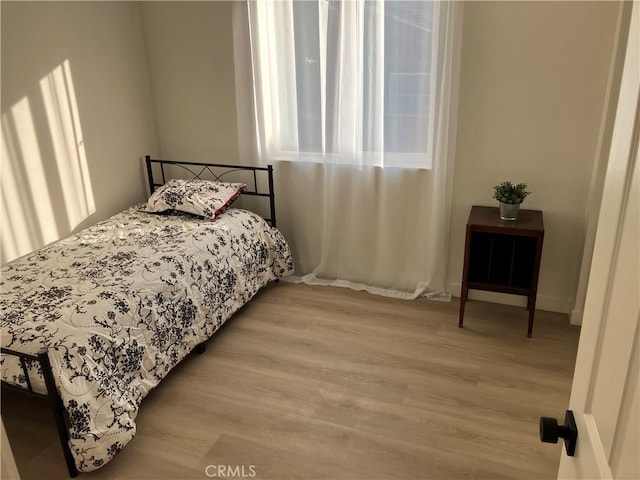 bedroom with light wood-style flooring and multiple windows