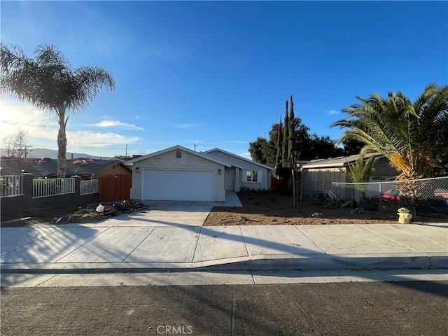 view of front of property featuring a garage, fence, and driveway