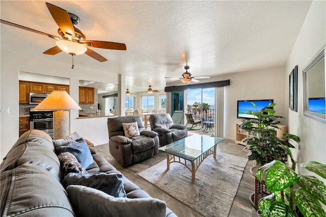 living area with light wood-type flooring and a ceiling fan