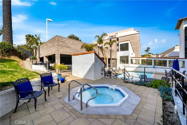 view of swimming pool featuring a patio and a hot tub