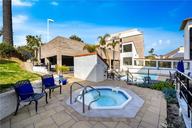 rear view of property featuring a hot tub and a patio