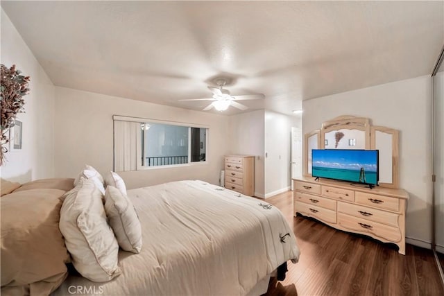 bedroom with baseboards, dark wood finished floors, and a ceiling fan