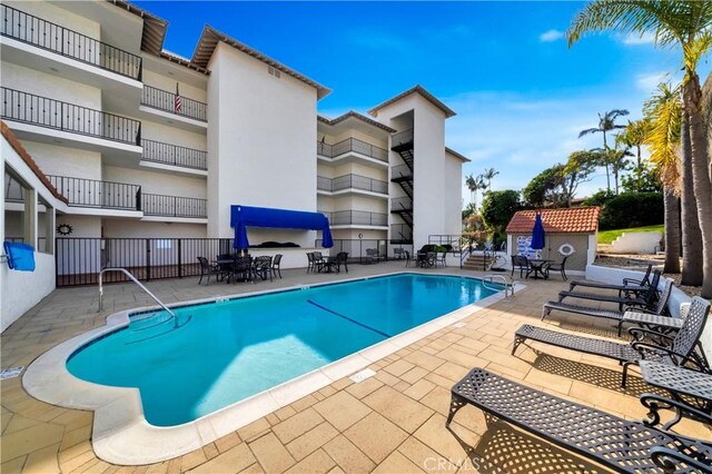 pool with a patio area and fence