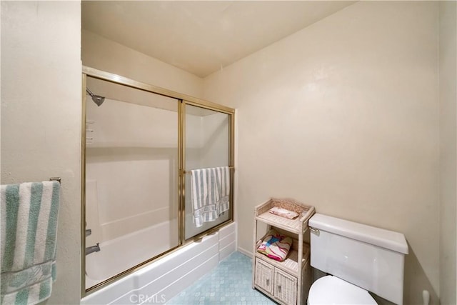 full bath with combined bath / shower with glass door, tile patterned flooring, and toilet