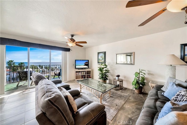 living area with a ceiling fan and a textured ceiling