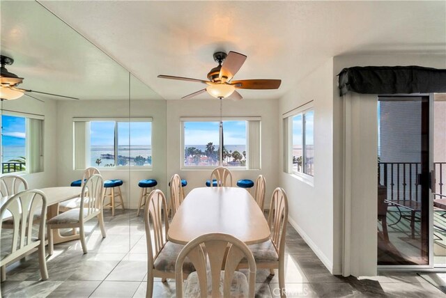 dining room with a healthy amount of sunlight, a ceiling fan, and baseboards