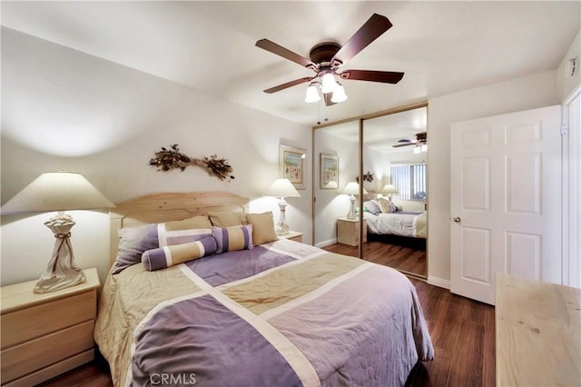 bedroom featuring dark wood-type flooring, a closet, baseboards, and a ceiling fan