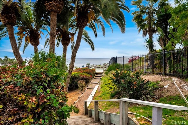view of community with fence and a water view