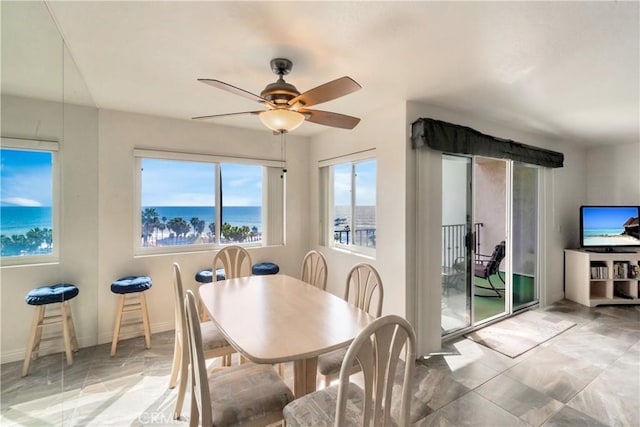 dining space with a ceiling fan and baseboards