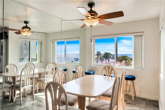 dining space featuring plenty of natural light, a ceiling fan, and baseboards
