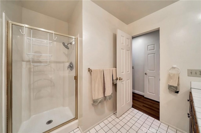 bathroom with tile patterned floors, baseboards, and a stall shower