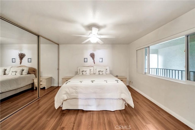 bedroom featuring ceiling fan, baseboards, and wood finished floors