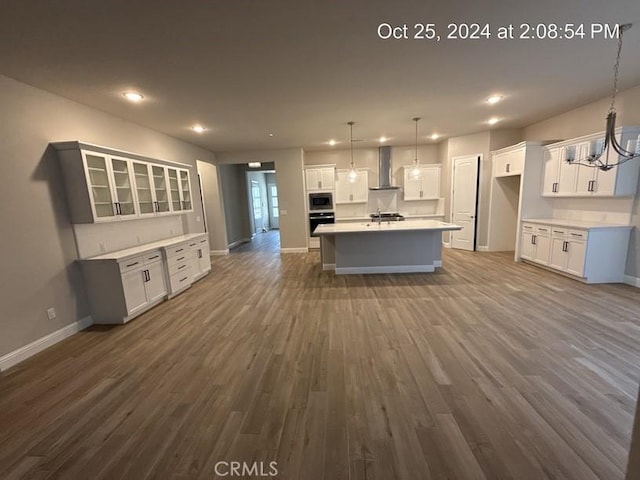 kitchen with appliances with stainless steel finishes, white cabinetry, dark wood finished floors, and wall chimney exhaust hood