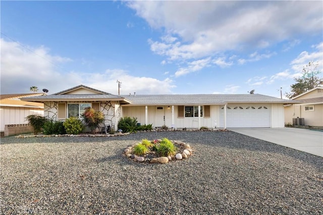 single story home with a garage, concrete driveway, and central AC