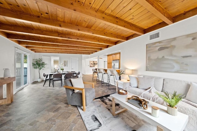 living room with wood ceiling, visible vents, beamed ceiling, and stone finish flooring