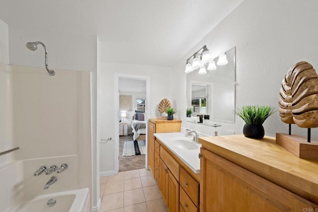 bathroom featuring tile patterned flooring, vanity, washtub / shower combination, and ensuite bathroom