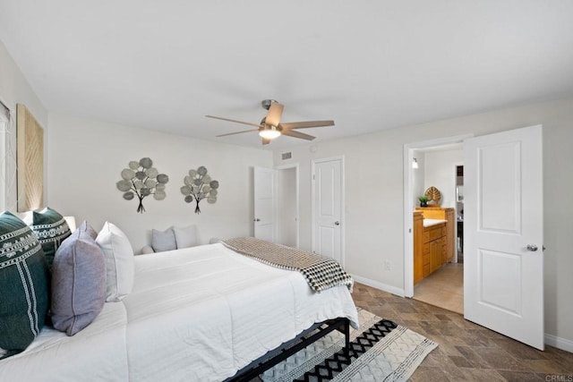 bedroom featuring baseboards, stone finish floor, and a ceiling fan