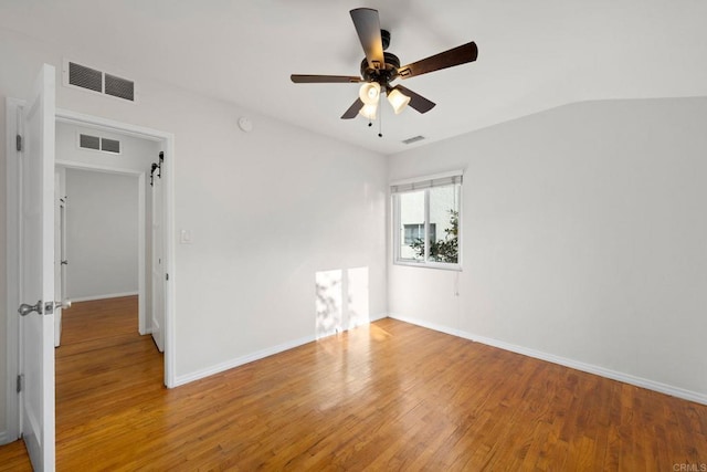 spare room featuring light wood-style floors, visible vents, and ceiling fan