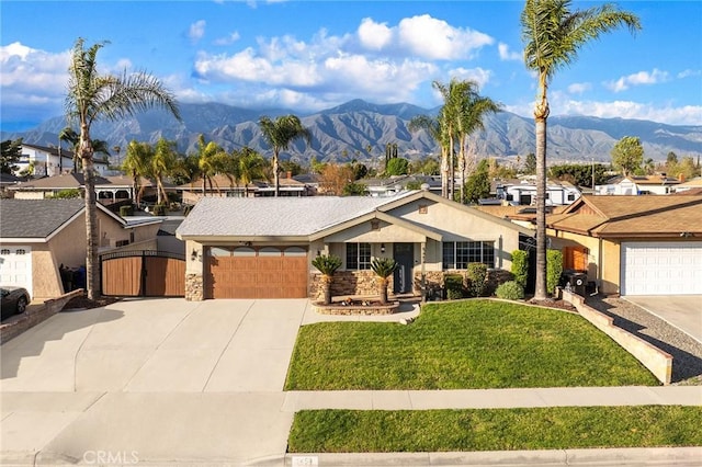 view of front of property with concrete driveway, a front yard, a gate, a mountain view, and a garage