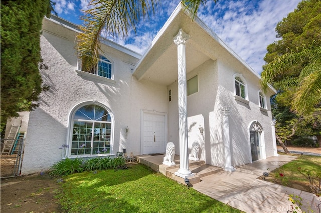 view of front of house featuring a front lawn and stucco siding