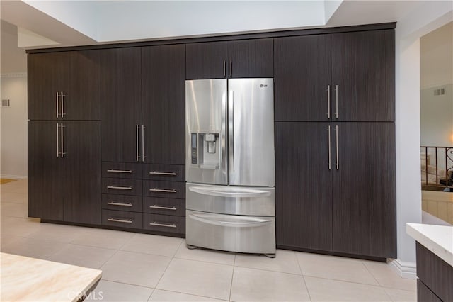 kitchen with light countertops, visible vents, stainless steel refrigerator with ice dispenser, and dark brown cabinets