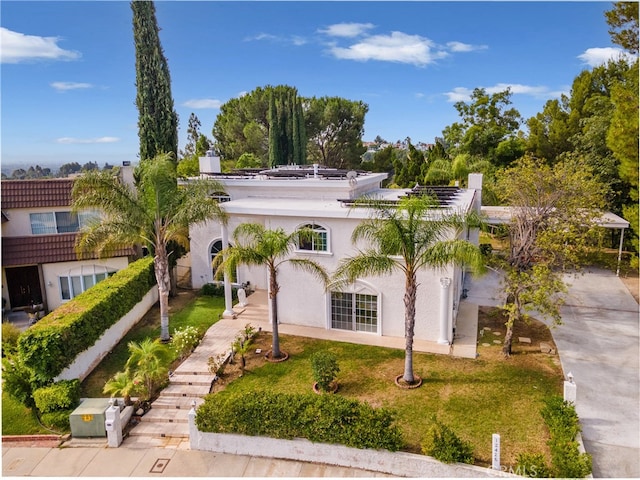 mediterranean / spanish home with a front yard and stucco siding