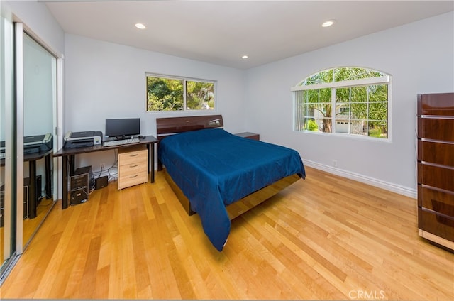 bedroom with recessed lighting, light wood-style flooring, and baseboards