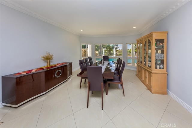 dining room with light tile patterned floors, baseboards, and crown molding