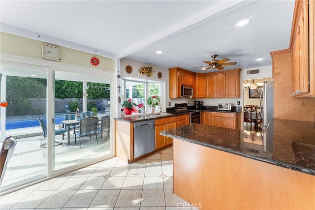 kitchen featuring recessed lighting, visible vents, appliances with stainless steel finishes, a sink, and a peninsula