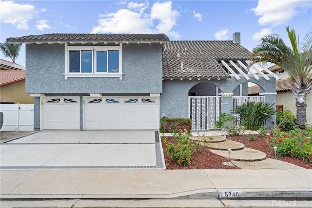 view of front of property featuring a tile roof, stucco siding, concrete driveway, an attached garage, and fence